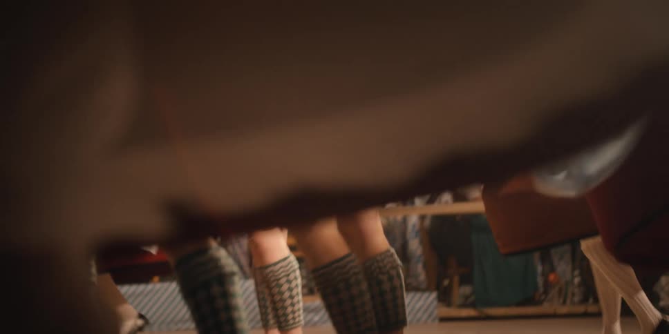 Men and women in dirndl and lederhosen dance at an oktoberfest celebration