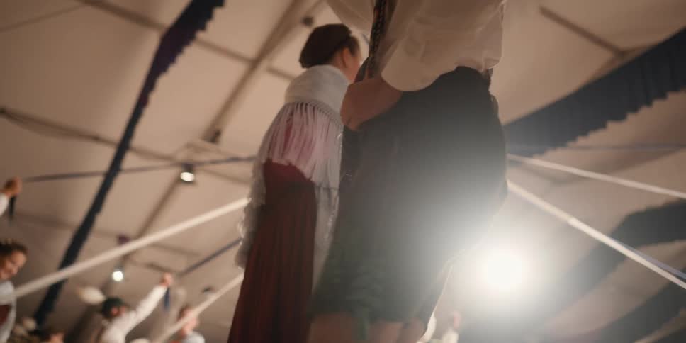 Men and women dancing around a pole at a celebration