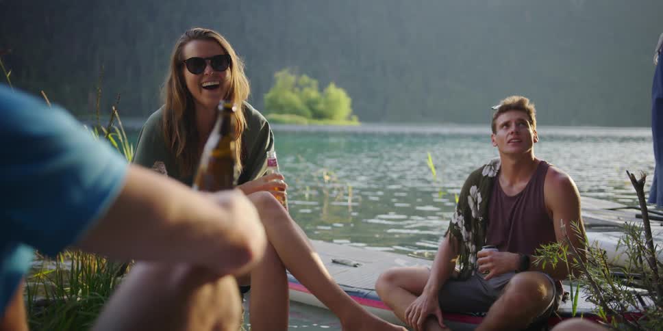 People sit around together laughing and drinking