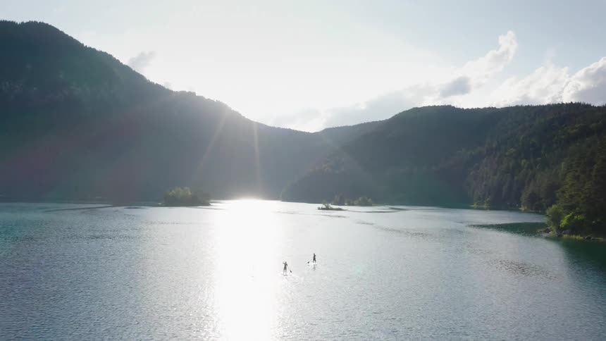 People are rowing on their surfboards in the lake