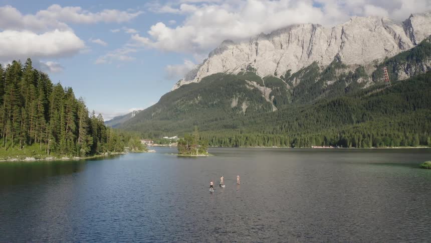 Paddleboarders go across a lake