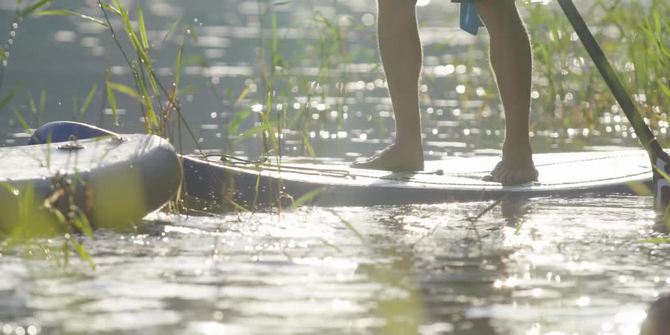 Close up of person stuck in weeds on a lake while paddleboarding