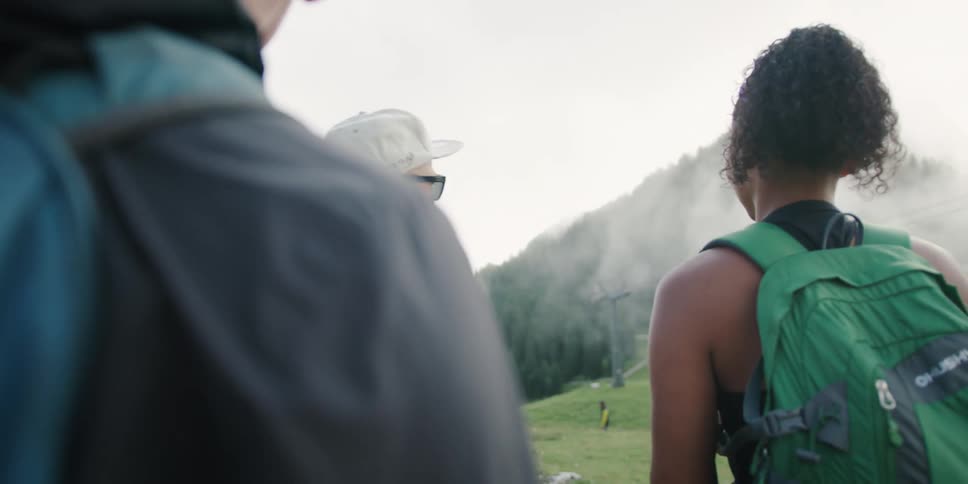 A man giving an explanation to a crowd why gesturing towards a mountain