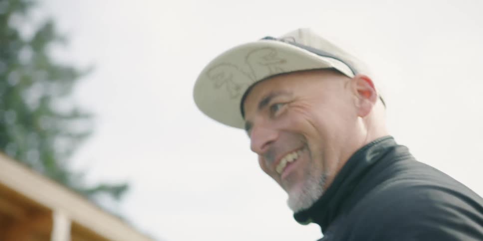 A man laughs as he tightens a womans back pack
