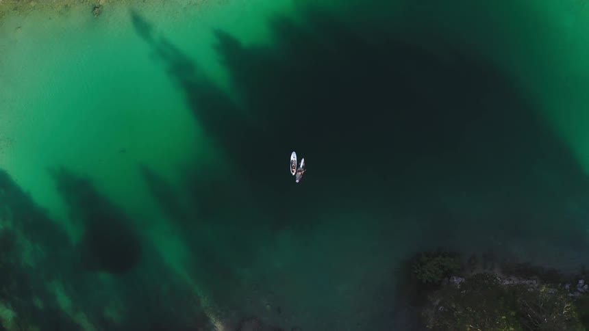 Two white canoes in the middle of a pond