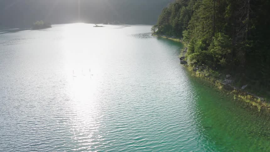 Three people paddle surfboards in the lake together