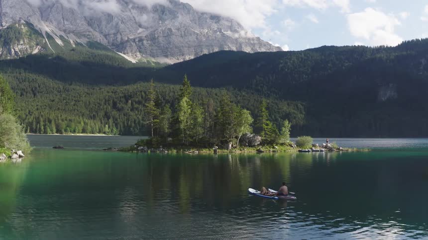 People drift across the water toward passage between island and shore