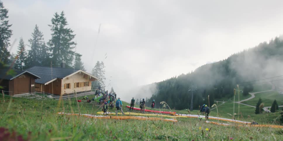 A group of people wearing back packs stand outside a house