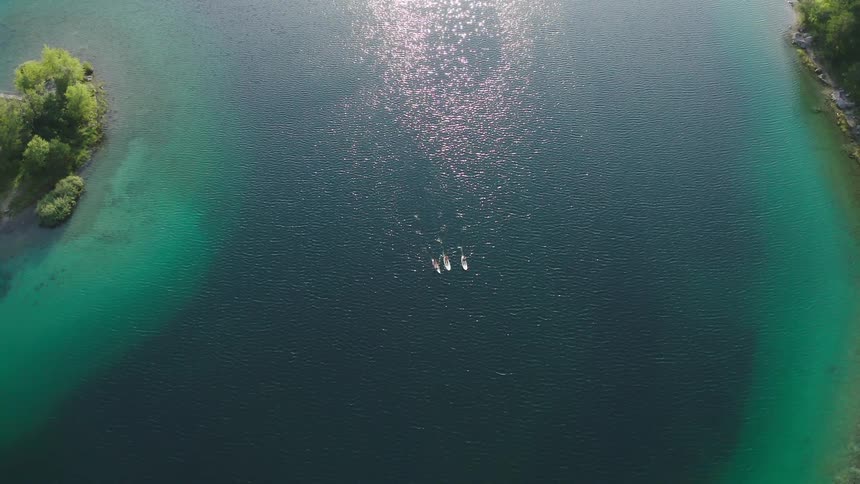 Three people paddle boarding in the middle of a lake
