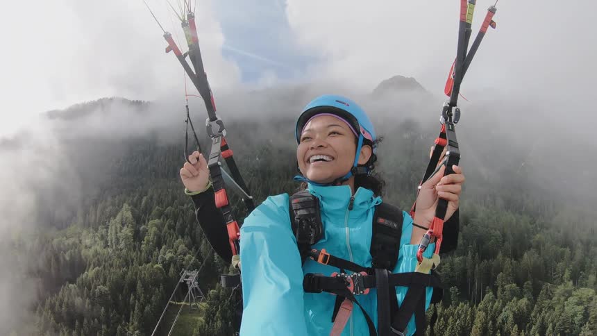 Asian woman and man go paragliding and travel a long horizontal distance in the air