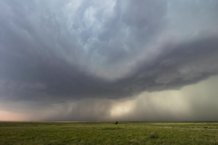 Lightning strikes as a storm rolls in over a field