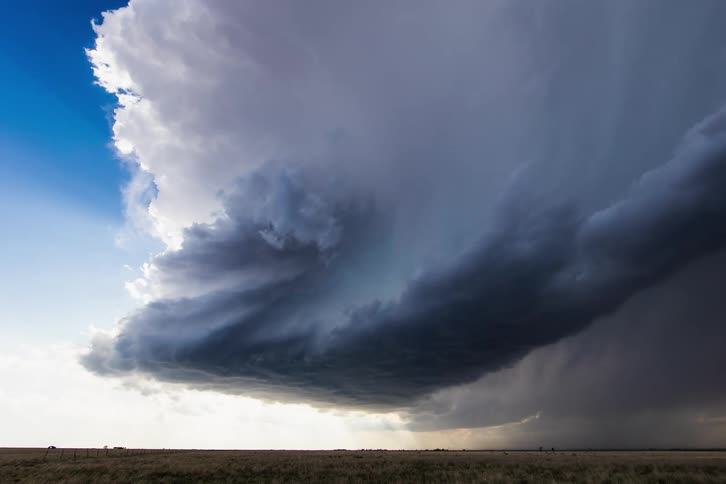 Storm clouds quickly build up over a flat stretch of land