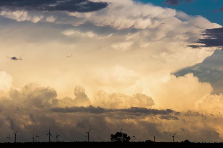 Timelapse of clouds moving over wind turbines at sunset
