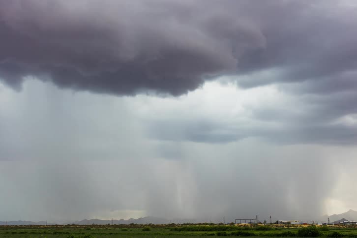 Timelapse of storm clouds releasing rain over small town in plains