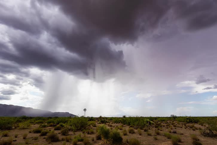 The rain pours over the desert ahead