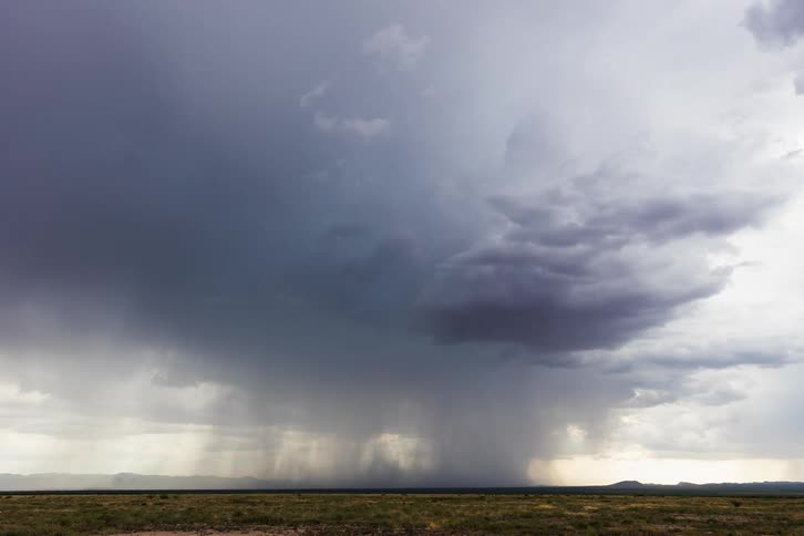 A powerful tornado sweeping across a field in the country in slow motion