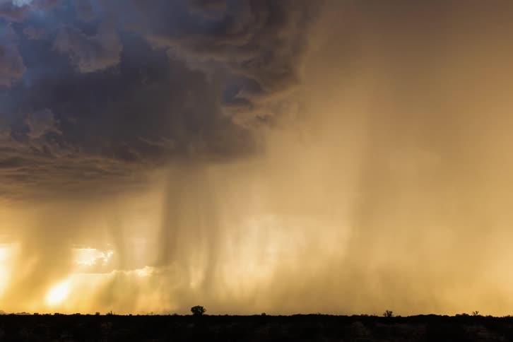 Time lapse of rain falling and clouds moving across the land during a storm