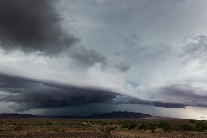 The storm rolls over the road on the field