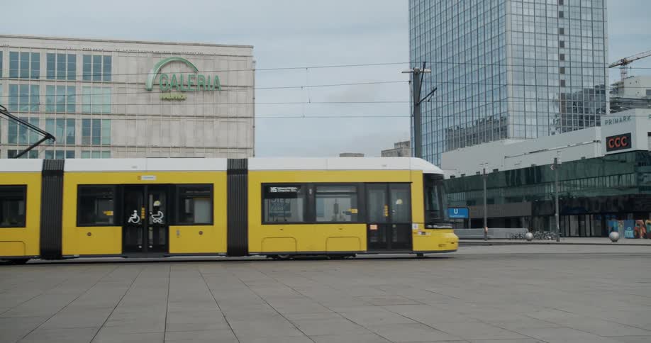 A city with a yellow trolley and buildings in the background