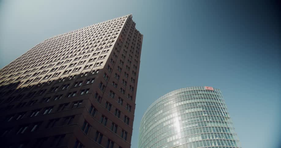 Top portion of skyscrapers brightly lit while bottom half is cast in shadows