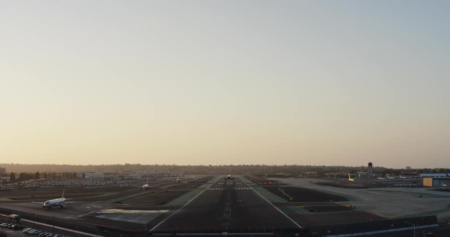 Airplane landing in airport at sunrise