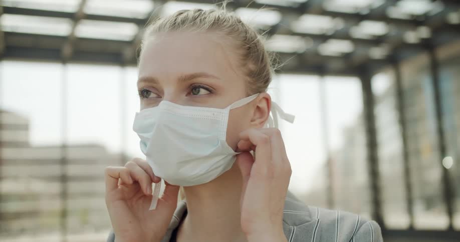 A woman puts on a medical mask