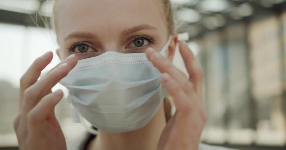A woman adjusting her mask