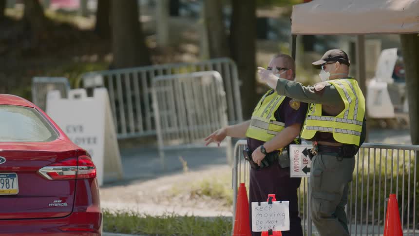 Two police officers wave a car by