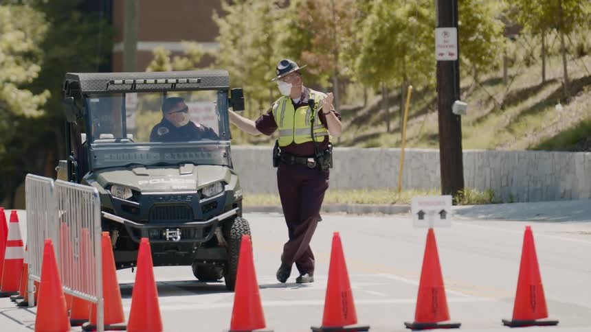 Two police officers talk as cars drive by