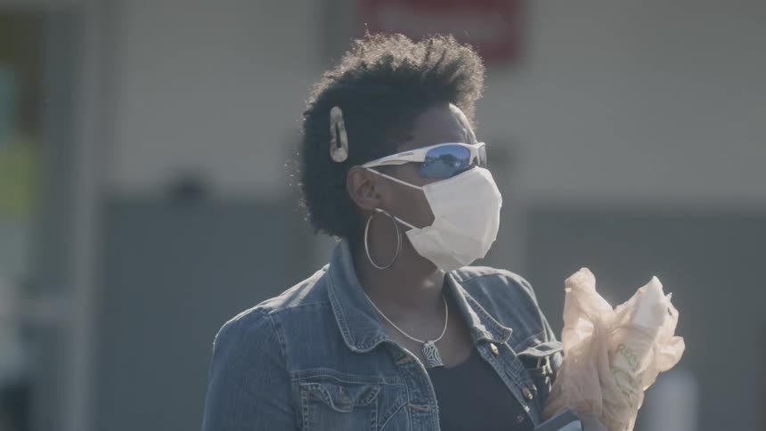 A woman with a face mask walking on the streets