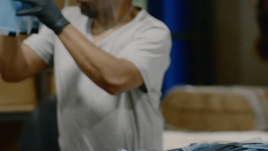Man loads manufactured items into a cardboard box