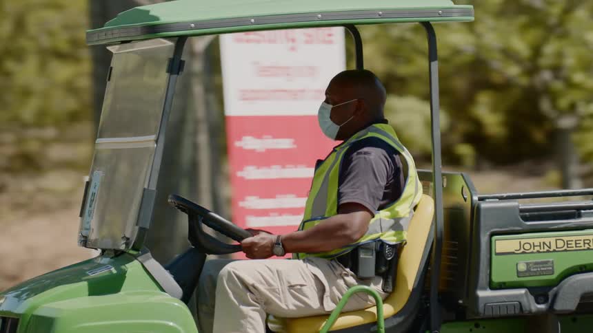A man wearing a mask is driving a tractor for construction