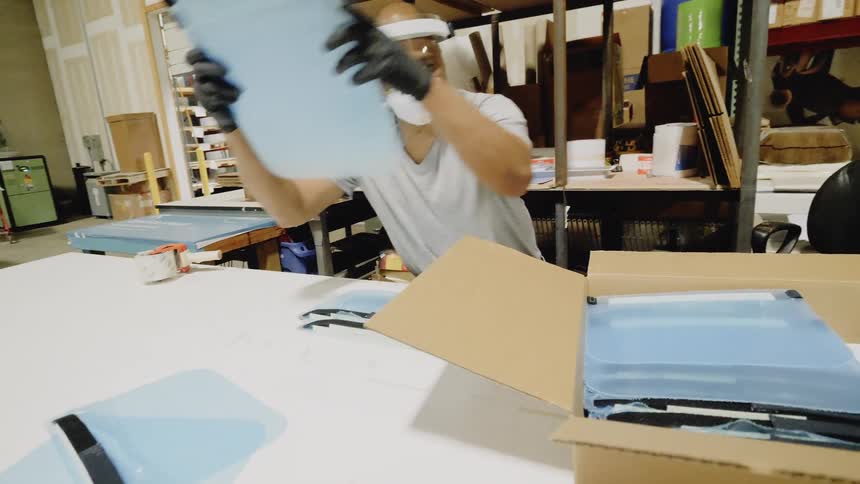 A man in a factory packs a box