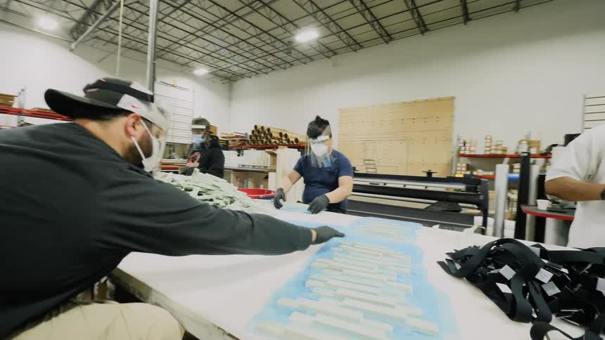 Workers wearing face mask assembly products in warehouse
