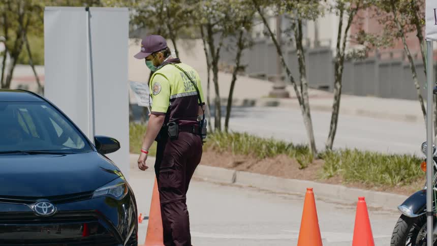 Police officer wearing face mask stops car at control point