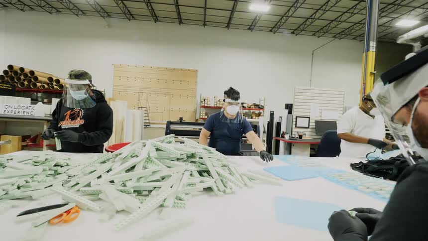 Men in a factory with mask and face shields