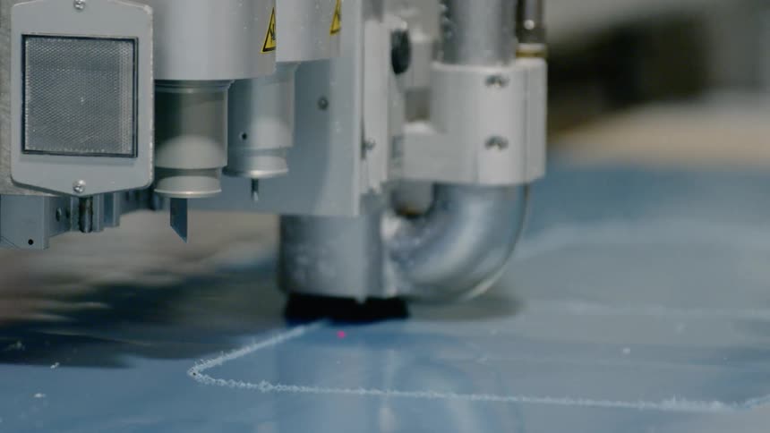 A machine carves shapes in the plastic