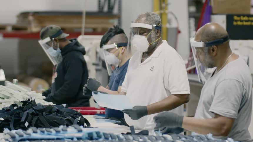 People are lined up packing items in a warehouse