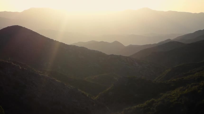 The morning sun shines over mountains