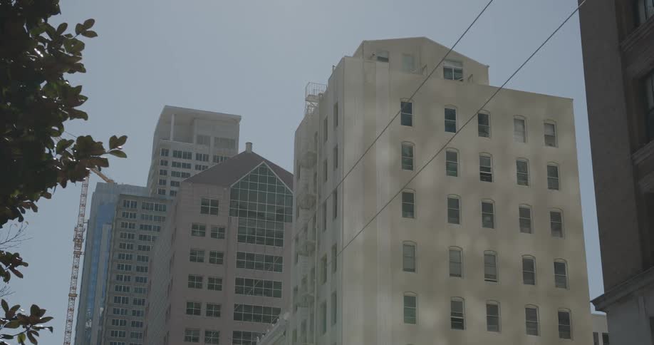 A construction crane up against an office building in a downtown area