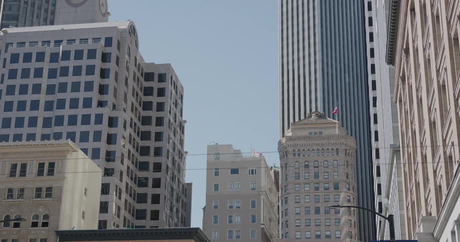 Flags on poles on rooftops in the breeze on a sunny blue sky day in the city