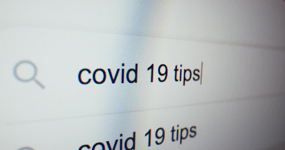 Someone types in covid 19 tips on a computer screen
