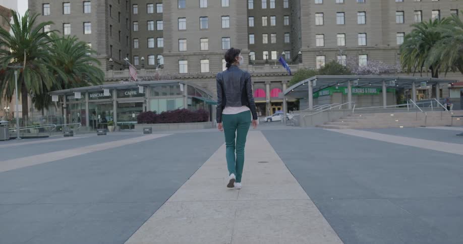 A woman walking alone in a plaza