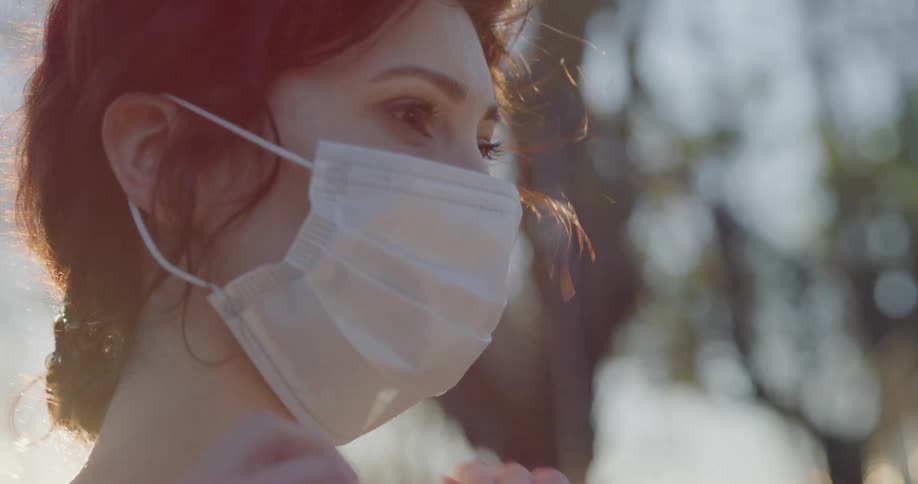A woman puts on a face mask