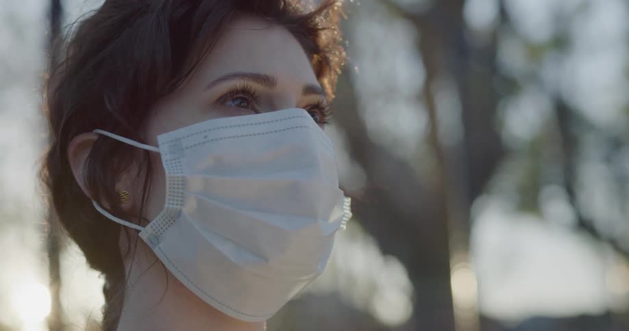 A woman in a face mask standing outdoors