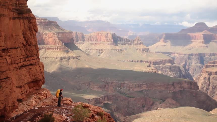 A hiker overlooks a canyon in the desert