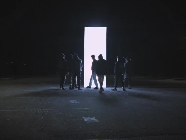 The people walk away from a glowing pillar in the parking lot