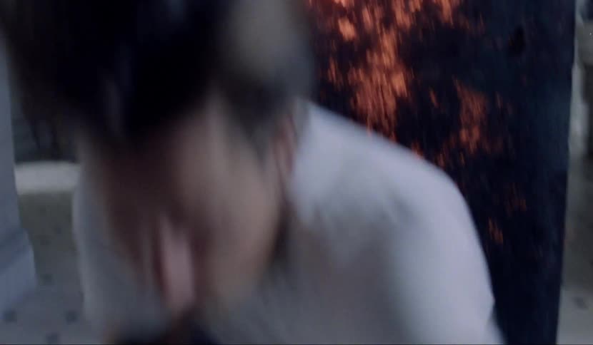 A teen quickly rolls away from a lit up piece of wood