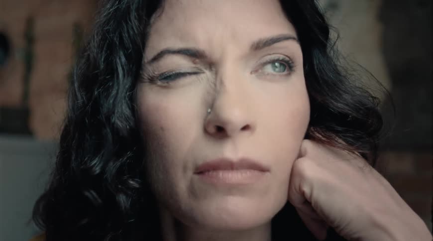 Hazel eyed woman blinks her eyes several times at home