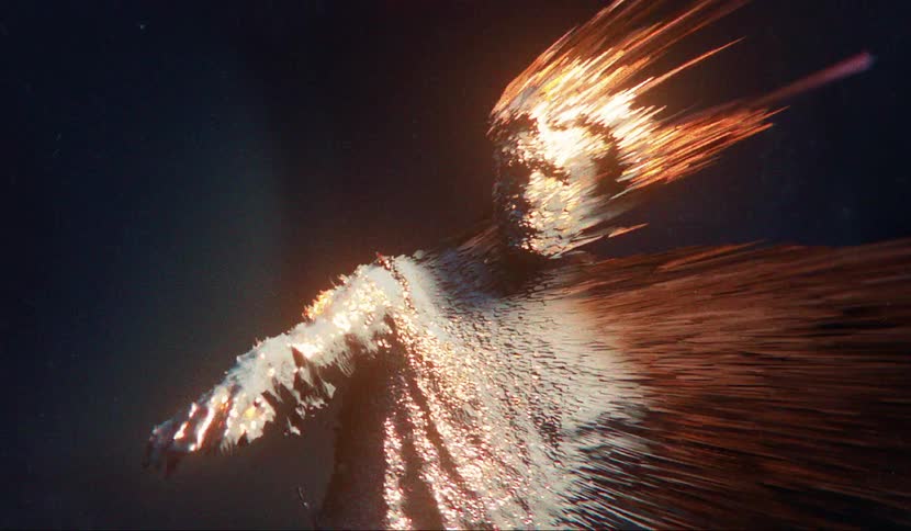 A teenager reaches his hand forward as flames come off his body